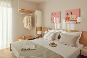 a bedroom with a bed with a plate of food on it at Eol Apartments Split Žnjan Beach in Split
