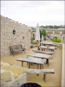 a row of wooden benches with an umbrella and a building at Agroturisme Son Torrat in Petra