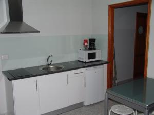 eine kleine Küche mit einer Spüle und einer Mikrowelle in der Unterkunft MAGNIFICO Apto.6 pax, TABLERO 6, cerca PLAYA INGLES in El Tablero