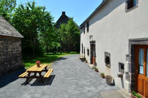 a patio with a picnic table next to a building at L'Abri du Berger in Olby