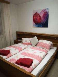 ein Bett mit roten und weißen Decken und einem Gemälde in der Unterkunft Ferienwohnung Wörndl in Faistenau