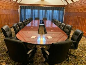 Host Inn an All Suites Hotel في ويلكس-بار: قاعة اجتماعات كبيرة مع طاولة وكراسي كبيرة