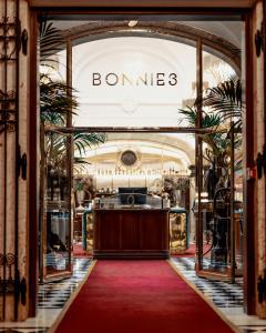 a store entrance with a red carpet and a sign that reads bonnes at Bank Hotel, a Member of Small Luxury Hotels in Stockholm