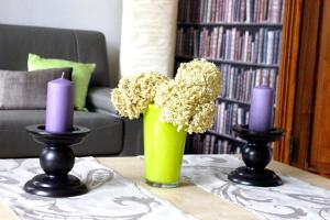 two candles and flowers in a vase on a table at Holiday Home Alice House in Ieper