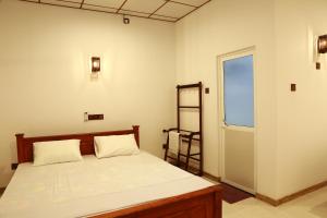 1 dormitorio con cama, ventana y escalera en Dearly Holiday Home And Safari, en Tissamaharama