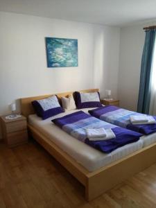 een slaapkamer met een groot bed met blauwe kussens bij Ferienwohnung Wörndl in Faistenau