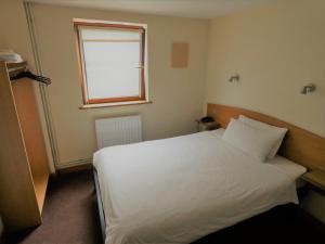 Tempat tidur dalam kamar di Hounslow Central Hotel
