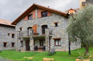 a large stone building with a balcony on the side at Casas la Ribera Ordesa in Escalona
