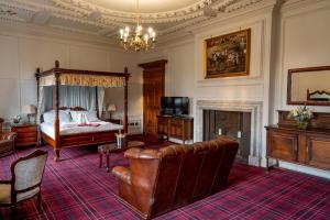 ein Schlafzimmer mit einem Bett, einem Sofa und einem Stuhl in der Unterkunft Castle Bromwich Hall; Sure Hotel Collection by Best Western in Birmingham