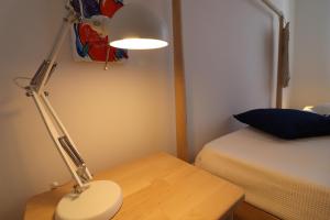una lampada seduta su un tavolo accanto a un letto di Casa Vacanze Nike a Otranto a Otranto