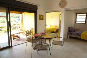 a living room with a table and chairs and a bedroom at cap vanisa in Saint-Joseph