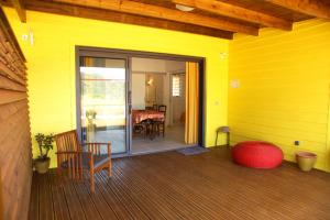 ein gelbes Haus mit einer Glasschiebetür mit einem Tisch in der Unterkunft cap vanisa in Saint-Joseph