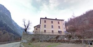 ein Haus auf einer Steinmauer neben einem Berg in der Unterkunft Appartement Orelle - Val Thorens in Orelle