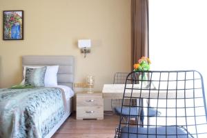 a bedroom with a bed, chair, and desk at Golden Palms Guest House & Cafe in Famagusta
