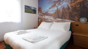 een slaapkamer met een bed met twee handdoeken erop bij Italianway - San Giovanni 13/A in Bormio