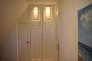 a white closet with two lights on top of it at Ferienwohnung-Clarissa in Morsum
