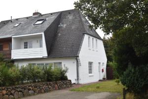 a white house with a black roof at Ferienwohnung-Clarissa in Morsum
