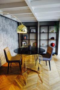 uma sala de jantar com uma mesa de vidro e 2 cadeiras em Loft Royal des Promenades em Reims