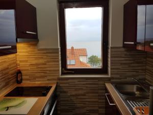 una cocina con fregadero y una ventana. en Apartments Katja en Mali Lošinj