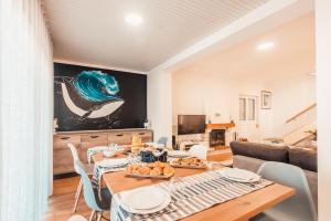 a dining room with a table and a couch at Baleia Atlantic - Piscina in Santa Cruz