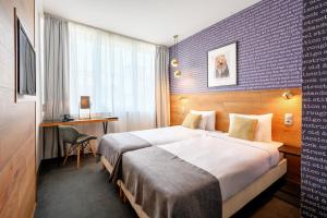 a hotel room with a large bed and a desk at Roombach Hotel Budapest Center in Budapest
