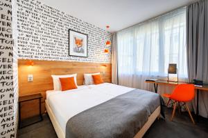 a hotel room with a bed and a desk and a chair at Roombach Hotel Budapest Center in Budapest