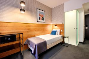 a hotel room with a bed and a tv at Roombach Hotel Budapest Center in Budapest