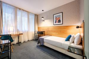 a bedroom with a bed and a desk and a window at Roombach Hotel Budapest Center in Budapest