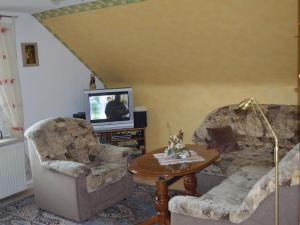 a living room with two chairs and a television at Ferienwohnung Katzmann in Kromsdorf