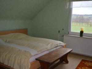 1 dormitorio con cama y ventana en Ferienwohnung Katzmann, en Kromsdorf