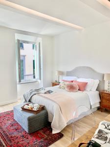 een witte slaapkamer met een groot bed en een rood tapijt bij NR8 - Santa Croce Apartment in Florence