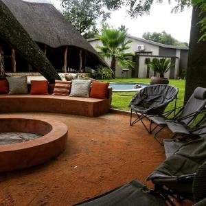 um pátio com um sofá e cadeiras e uma piscina em AFRICAN DREAMS GUESTHOUSE em Okahandja