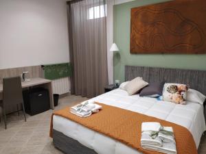 - une chambre avec un grand lit et des serviettes dans l'établissement La Casa di Halley, à Naples