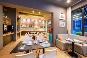 a restaurant with tables and chairs and a couch at Roombach Hotel Budapest Center in Budapest
