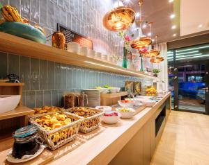 a buffet line with food on it in a restaurant at Roombach Hotel Budapest Center in Budapest