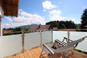 奧伊米特爾貝格的住宿－Alpspitzblick，阳台配有椅子,享有房屋的景致。