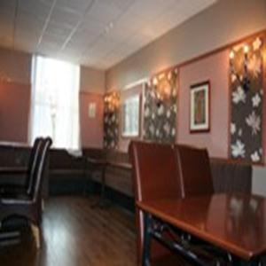 a dining room with a wooden table and chairs at Royal Hotel in Girvan