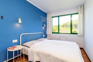 ein blaues Schlafzimmer mit einem Bett und einem Fenster in der Unterkunft SR-32 BEGUR SA RIERA 4 PAX in Begur