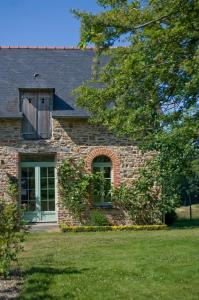 a brick house with a window and a door at Tillac Chambres d'hôtes in Pléchâtel