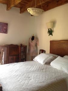 1 dormitorio con 1 cama y un vestido colgado en la pared en Ma maison de couture, en Urval