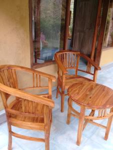 a group of three wooden chairs and a table at Loka Amertha in Sidemen