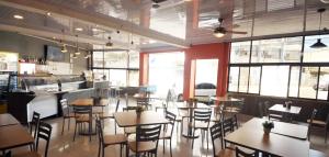 a restaurant with tables and chairs in a room with windows at Hotel Milan Costa Rica in San José