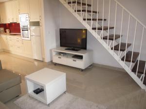 een woonkamer met een televisie en een trap bij Hernan Cortes in Nerja