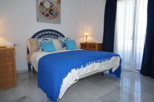 una camera da letto con un letto blu e bianco con cuscini blu di Vinamar a Nerja