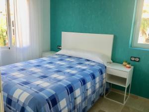 アルビールにあるAlbir 21 by Albir Proper Propertiesの青と白のベッドと窓が備わるベッドルーム1室が備わります。