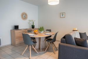 a dining room with a table and a couch at FIRMIN MARBEAU #13 - Espace citadin - 1 Chambre in Brive-la-Gaillarde