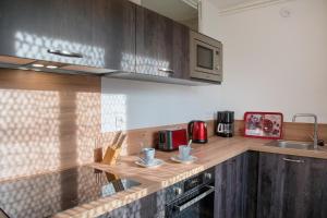 eine Küche mit einer Arbeitsfläche aus Holz und einem Waschbecken in der Unterkunft TURGOT #80 - L'Appart. 100% Gaillard - 2 chambres in Brive-la-Gaillarde