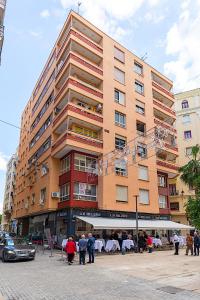 a large building with people walking in front of it at Rooms Young People Only, Soho CityCenter in Málaga