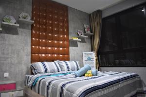 Un dormitorio con una cama con cabecero de madera. en i-City-Casa Rosa - Wifi - Netflix - Movies - Parking - Sleeps 5 pax, en Shah Alam