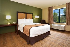 a hotel room with a large bed and a window at Extended Stay America Suites - Chicago - Woodfield Mall in Schaumburg
